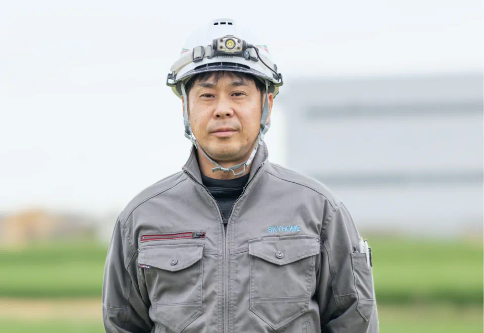 ヘルメットと作業着を着用した社員K.Yのポートレート