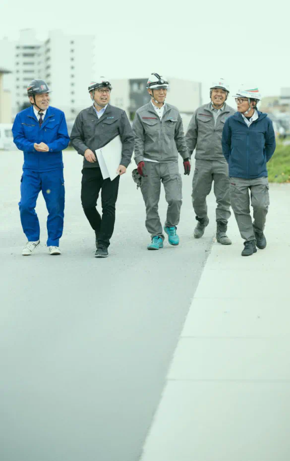 まずは15分、私たちと「技術の話だけ」をしてみませんか？ 笑顔で並び歩く社員たちの背景イメージ