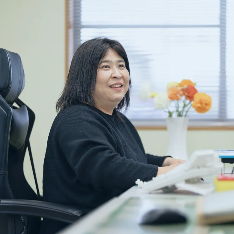 オフィスにて、社長が若い社員へ図面を指し示しながら、専門知識を指導している様子